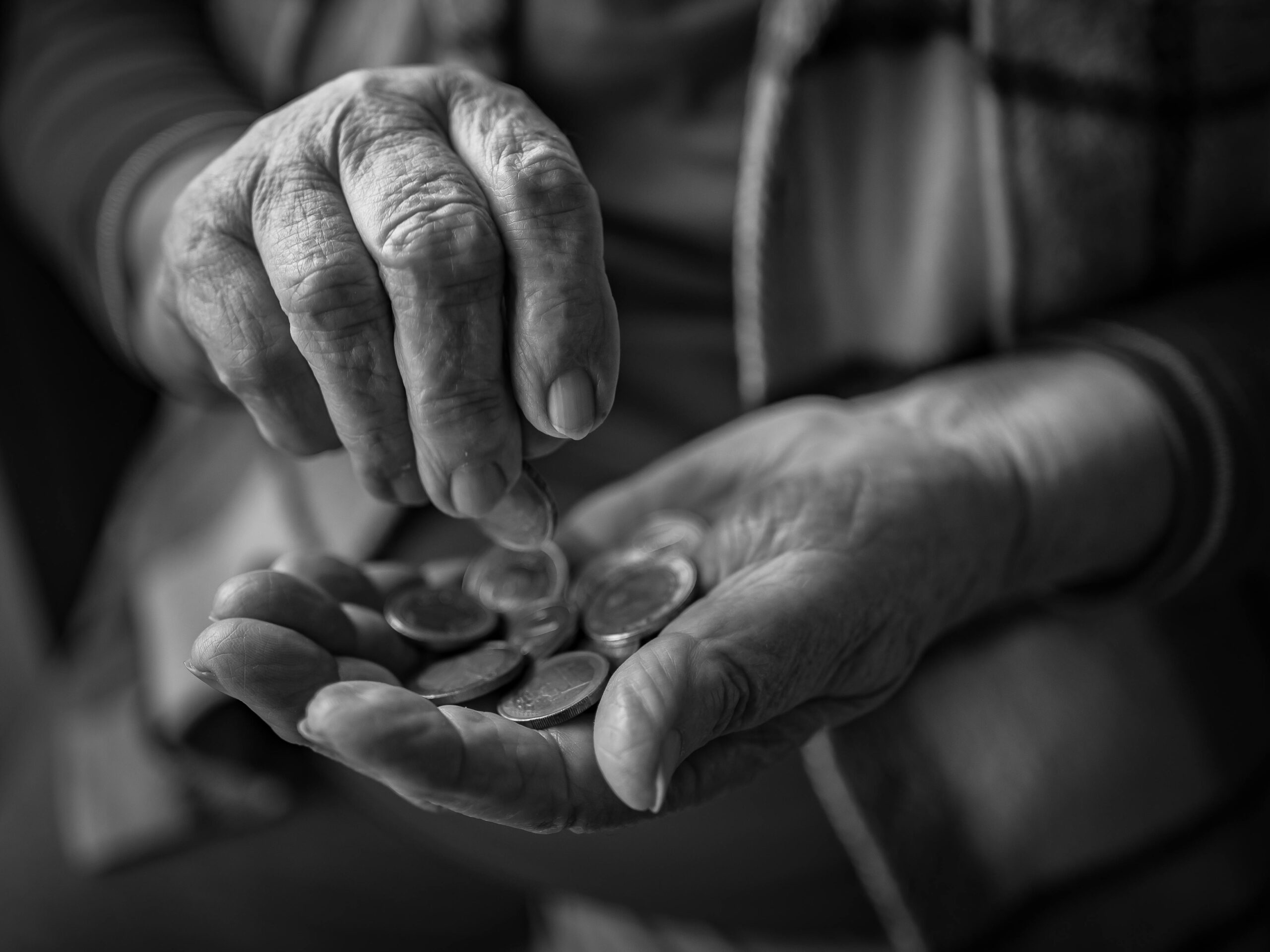 Older person's hands holding coins, representing the value of intergenerational projects